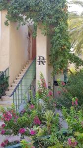 a building with a staircase and flowers in front of it at Rivkas zimmer in Ein Gedi