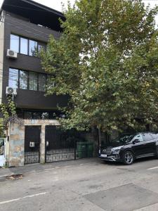 een zwarte auto geparkeerd voor een gebouw bij Studio in Boekarest