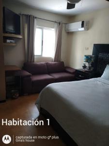 um quarto de hotel com uma cama e um sofá em Gina's house em Culiacán