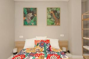 una camera con un letto con due immagini sul muro di AGUSTINA - Piso céntrico reformado en calle peatonal a Saragozza