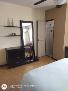 um quarto com um espelho e uma cómoda e uma cama em Gina's house em Culiacán