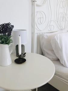a white table with a candle and a white bed at Dolce Vivere by Konnect, Gaios Paxos in Gaios