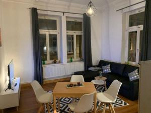 a living room with a couch and a table and chairs at Apartment am Schelfmarkt in Schwerin