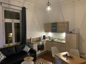 eine Küche und ein Wohnzimmer mit Sofa und Tisch in der Unterkunft Apartment am Schelfmarkt in Schwerin