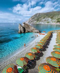 een strand met stoelen en parasols en de oceaan bij Appartamento per vacanze GAIA in Monterosso al Mare