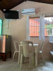 ein Esszimmer mit einem Tisch, Stühlen und einem TV in der Unterkunft Cabañas Ecologicas Cayapas in Atacames