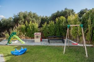 un parque infantil con 2 columpios y un banco en Villa Life, en Agia Marina de Nea Kydonia