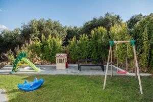 a playground with two swings and a bench at Villa Life in Agia Marina Nea Kydonias