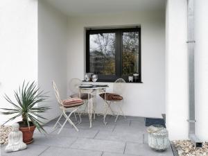 a patio with a table and chairs and a window at Oase am Großstadt Jungel in Erkrath