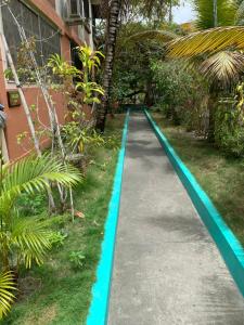 a path in a garden with a blue pool at Cabañas Ecologicas Cayapas in Atacames