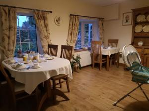 a dining room with two tables and chairs at White Cottage B and B in Spilsby