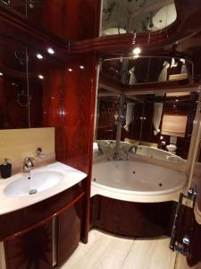 a bathroom with two sinks and a tub and a mirror at Rent Luxury Motor Yacht in Barcelona