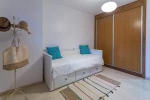 ラスパルマス・デ・グランカナリアにあるApartment NOUMELYAのベッドルーム1室(青い枕のベッド1台、クローゼット付)