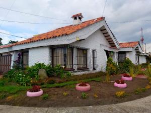 una casa con macetas rosas delante de ella en Villa Suite Emanuel, en Bogotá