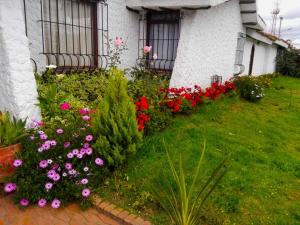 um jardim de flores em frente a uma casa em Villa Suite Emanuel em Bogotá