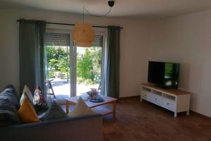 - un salon avec un canapé et une télévision dans l'établissement Klein-Tjücher-Grashaus 4, à Upgant-Schott