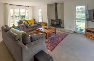 ein Wohnzimmer mit 2 Sofas und einem Holzofen in der Unterkunft Gem bed and breakfast in Christchurch