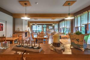 a dining room with a table and chairs and windows at Casa Muntelui in Fundata