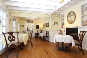 uma sala de jantar com duas mesas e uma lareira em Olallieberry Inn Bed and Breakfast em Cambria