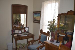 Habitación con escritorio, silla y espejo. en The Hotel Texan, en Seagraves