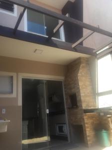 a building with a glass door and a window at Casa Enseada próximo ao mar e comércios com 2 ar split in São Francisco do Sul