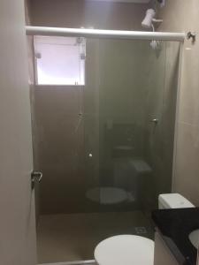 a bathroom with a shower with a toilet and a window at Casa Enseada próximo ao mar e comércios com 2 ar split in São Francisco do Sul +23 photos