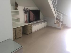 a living room with a tv and a staircase at Casa Enseada próximo ao mar e comércios com 2 ar split in São Francisco do Sul