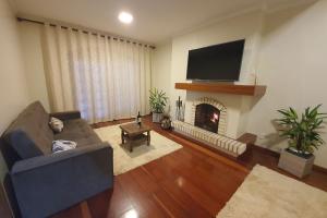 uma sala de estar com um sofá e uma lareira em Ap. de 4 quartos com ar condicionado a 150m da Rua Coberta em Gramado