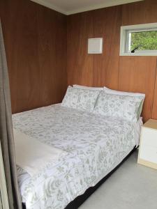 a bed in a small room with a window at Waihi Gold Alpacas 3 or 4 people in Waihi