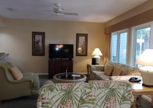 a living room with a couch and a tv at Ocean Palms Villa with Championship Golf Saturday to Saturday Rental in Hilton Head Island