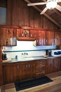 eine Küche mit Holzschränken und einem Waschbecken in der Unterkunft Main Cabin - STARRY NIGHTS cabin in Carp Lake