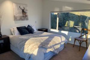 a bedroom with a bed and a window at Lakeview Heights Luxury Apartment 2 in Wanaka