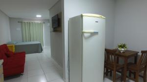 a living room with a refrigerator and a table at Residencial Zé Buscapé in Bombinhas