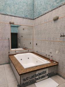 a bath tub in a bathroom with a mirror at Lual Motel Sorocaba-SP in Sorocaba +71 photos
