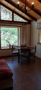a dining room with a table and chairs and a window at Cabañas Emporio de la Meme in San José de Maipo