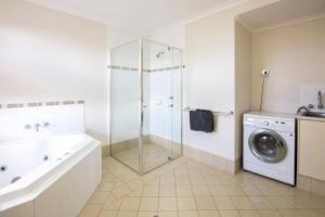 a bathroom with a shower sink and a washing machine at Pinnacles Edge Resort in Cervantes