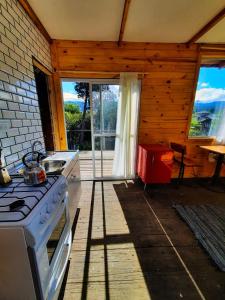 a kitchen with a stove and a large window at Santuario Patagonia in El Bolsón