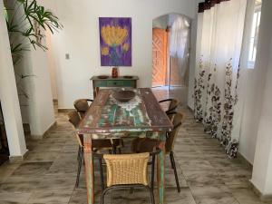 a dining room table with chairs and a painting on the wall at Praia das Cigarras São Sebastião a 50 metros da praia - Wi-Fi - 500 Mega in São Sebastião