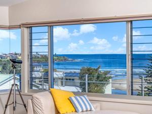 una sala de estar con una ventana con vistas al océano en Vue De La Mer Gerroa, en Gerroa