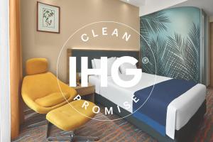 a room with a bed, chair and a painting on the wall at Holiday Inn Express Singapore Orchard Road, an IHG Hotel in Singapore