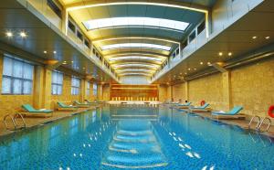 a large swimming pool with chairs in a building at Hotel Nikko Xiamen in Xiamen
