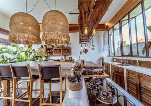 Villa Ubuntu by Optimum Bali Villas في كيروبوكان: مطبخ مع طاولة وكراسي ونوافذ