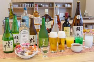 Kuretake Inn Premium Fukuroi Ekimae في Fukuroi: مجموعة من زجاجات النبيذ والمشروبات على طاولة