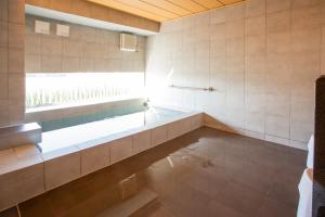 ein Bad mit einer Badewanne und einem Fenster in der Unterkunft Kuretake Inn Premium Fukuroi Ekimae in Fukuroi