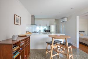 a kitchen with a table and two stools in a room at Mark and Kate's Place in Bendigo
