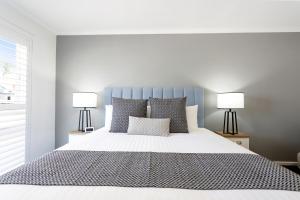 a bedroom with a large bed with two lamps at Sanctuary Inn on Westernport in Hastings