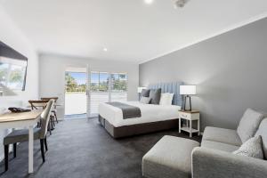 a hotel room with two beds and a table and chairs at Sanctuary Inn on Westernport in Hastings