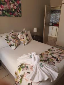 un letto con coperta bianca e cuscini sopra di Caledon Overnight Rooms a Kimberley