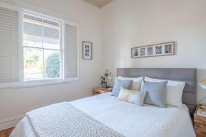een witte slaapkamer met een groot bed en een raam bij Mark and Kate's Place in Bendigo