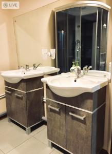 a bathroom with two sinks and a large mirror at Valencia Mini Hotel in Khabarovsk
